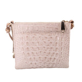 Cream embossed leather crossbody bag with zip closure and top carry loop detail.