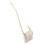 Small cream embossed crossbody bag with long strap, front flap, and metal clasp.