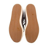 Rubber outsole view of Adidas mid-top sneakers with textured gum tread pattern