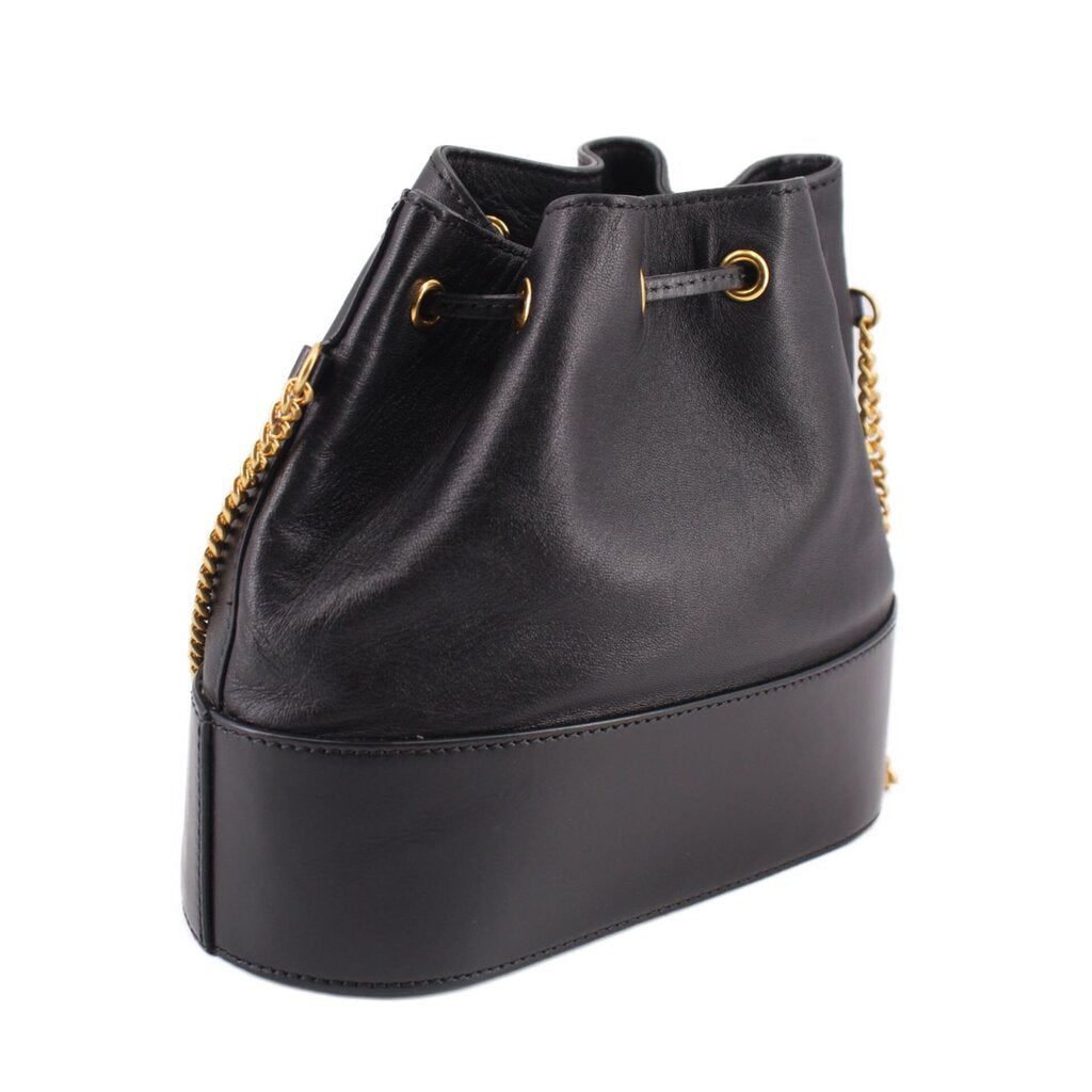 Black mini bucket crossbody bag with drawstring top, gold chain trim, rounded base