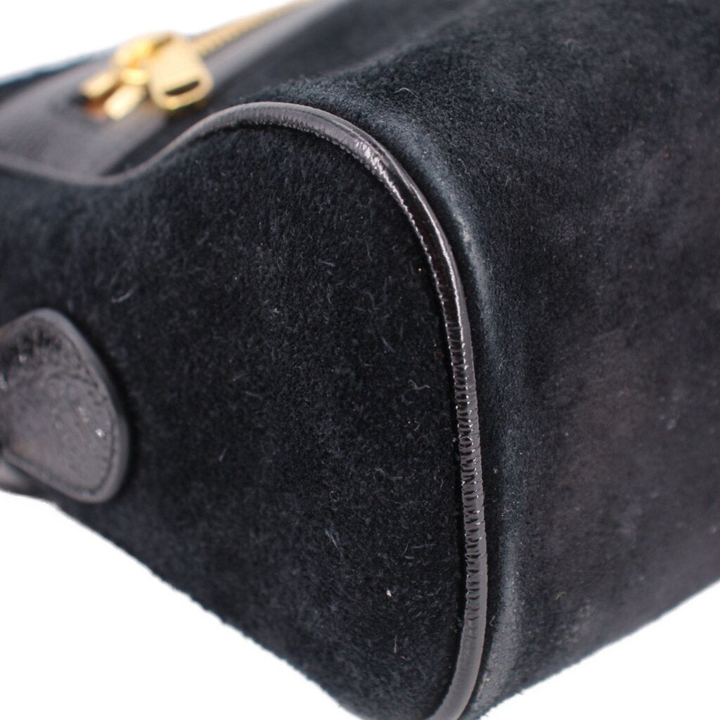 Black suede crossbody bag with gold-tone zipper pull and rounded flap detail