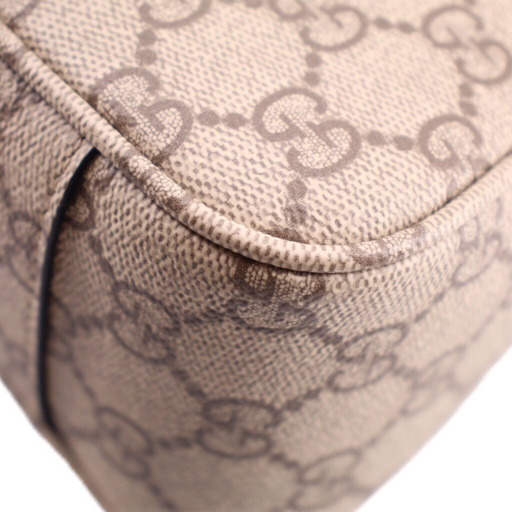 Close-up of GG monogram canvas corner with rounded edge and dark leather border