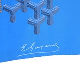 Blue silk scarf corner with white signature logo and patterned texture