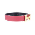 Red leather belt with black underside and gold-tone buckle hardware