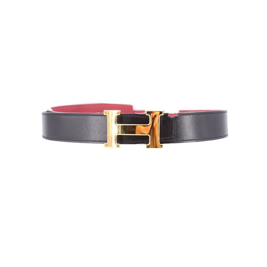 Black leather belt with gold-tone buckle and red strap detail at edge