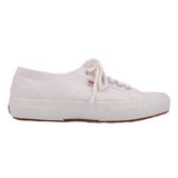 White canvas low-top sneakers with lace-up closure and textured rubber sole