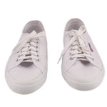 White canvas sneakers pair, front view with lace-up and metal eyelets.