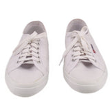 White canvas sneakers pair, front view with lace-up and metal eyelets.