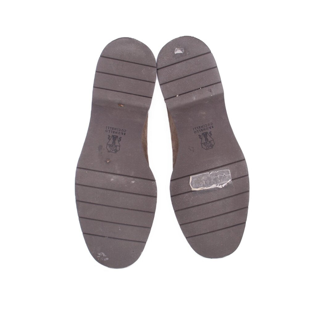 Taupe suede loafer outsoles with tread grooves and brand imprint