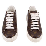 Pair of brown monogram low-top sneakers with white laces and white soles.