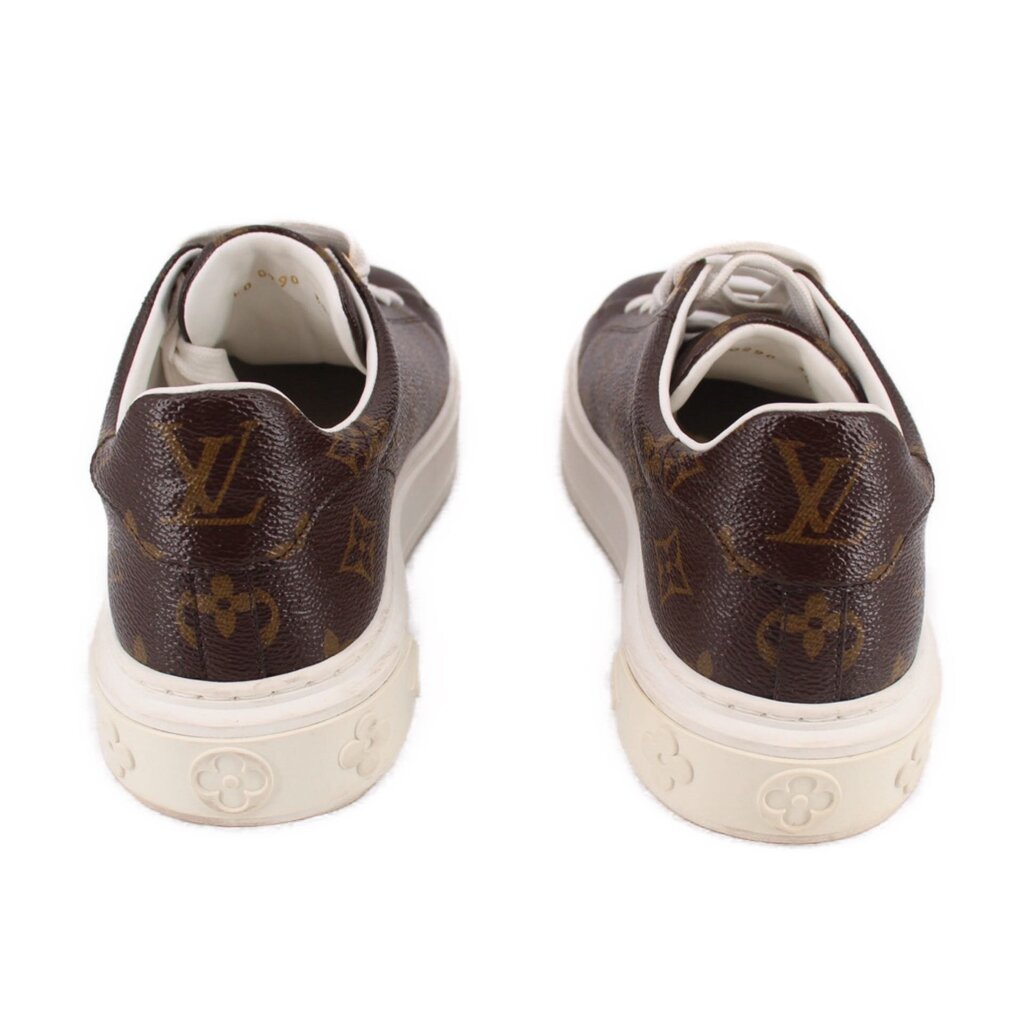 Brown monogram sneakers with white laces, rear view and embossed heel logo.