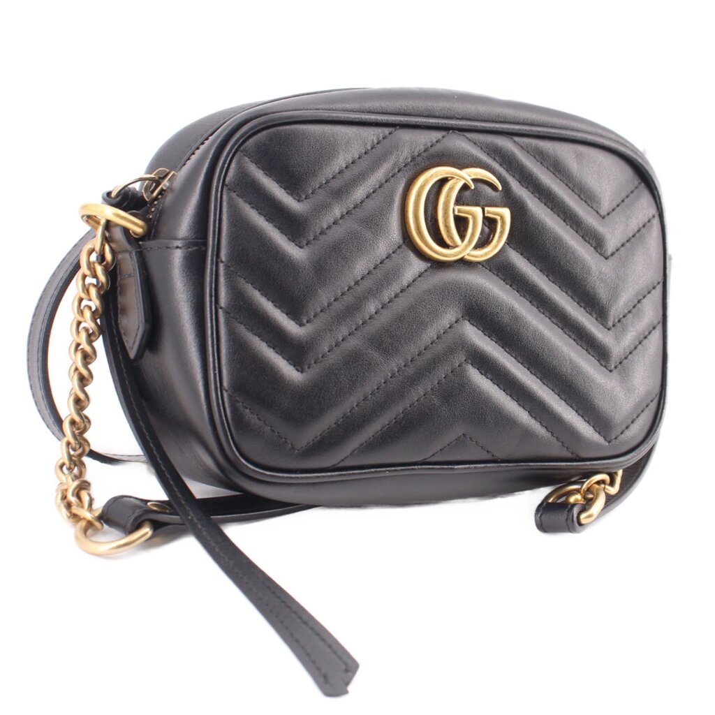 Black quilted leather crossbody bag with gold GUCCI emblem and chain shoulder strap