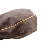 Close-up of monogram tote bag corner with tan piping and dark brown leather texture