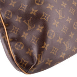 Close-up of monogram tote bag bottom corner with tan edge trim on dark brown patterned leather