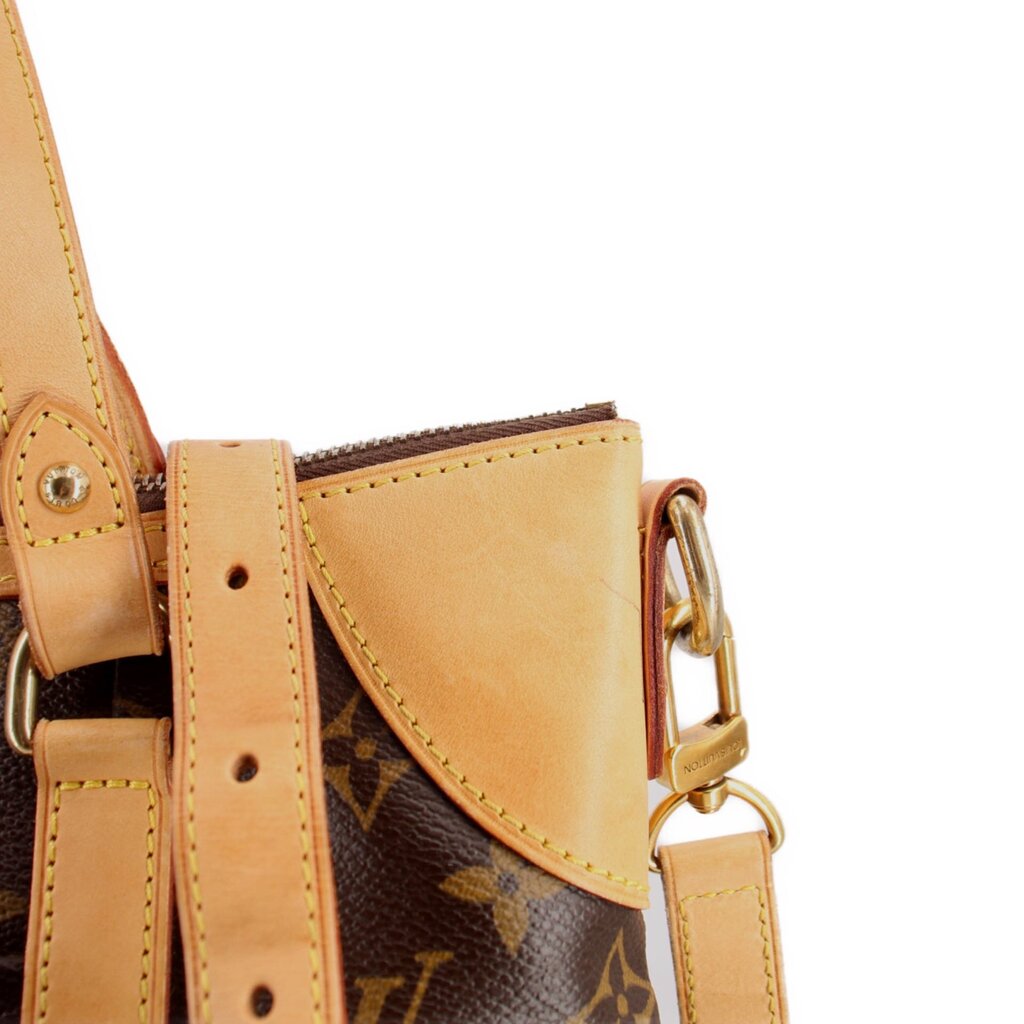 Monogram crossbody bag detail with tan trim, stitched flap, and gold hardware