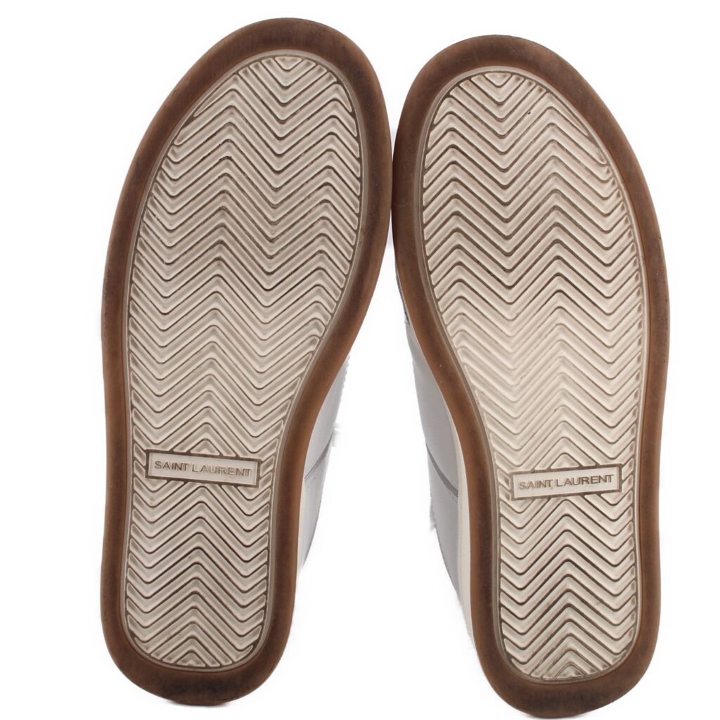 Shoe outsoles with herringbone tread and Saint Laurent logo on beige rubber