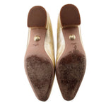 Metallic gold flats with brown leather soles and gold logo medallion