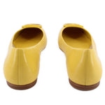 Yellow leather flats from heel view with brown outsole and visible heel seam