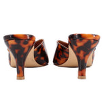 Back view of brown tortoise patent mule heels with open sides and slim heel