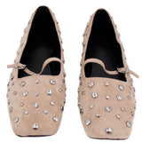 Pair of tan stud flats showing black lining and bow-tie strap