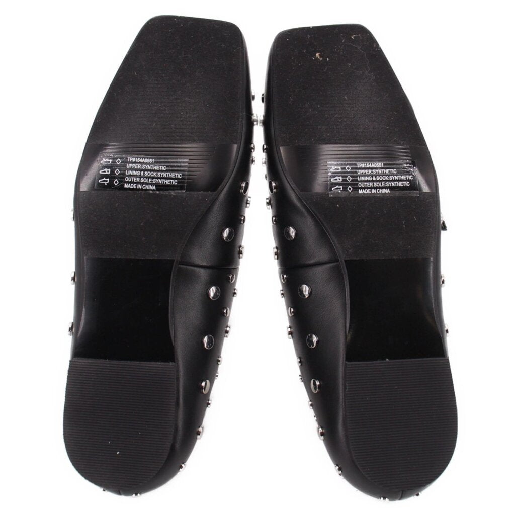 Black flats showing textured rubber outsole and silver-tone studs on sides