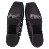 Black flats showing textured rubber outsole and silver-tone studs on sides