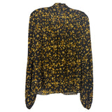 Back of the black floral blouse, showing long sleeves and a gathered upper-back seam