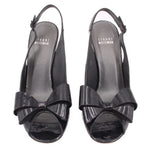 Pair of black patent slingback heels with bow across the vamp
