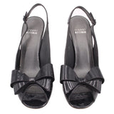 Pair of black patent slingback heels with bow across the vamp