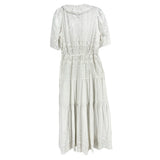 White eyelet dress with puff sleeves, high neck and gathered tiered skirt