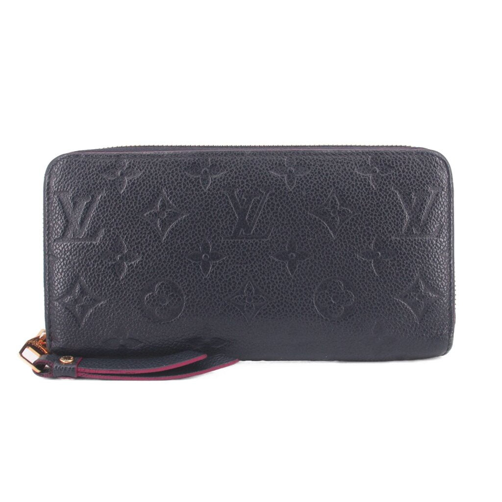 Navy embossed zip-around wallet with monogram pattern and smooth leather finish
