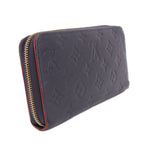 Navy embossed zip-around wallet with gold zipper and red-trimmed edge detail