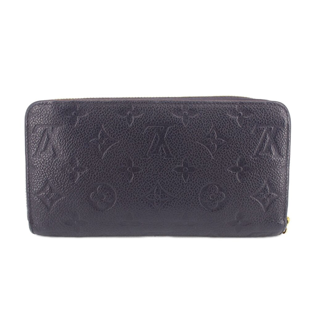Navy embossed zip-around wallet with monogram pattern, rounded corners, and smooth finish