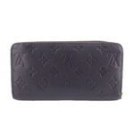 Navy embossed zip-around wallet with monogram pattern, rounded corners, and smooth finish