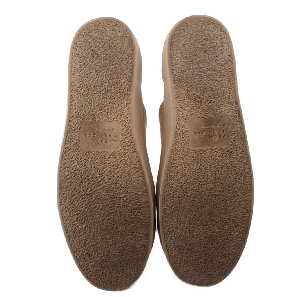 Tan suede sneakers with textured soles and embossed text