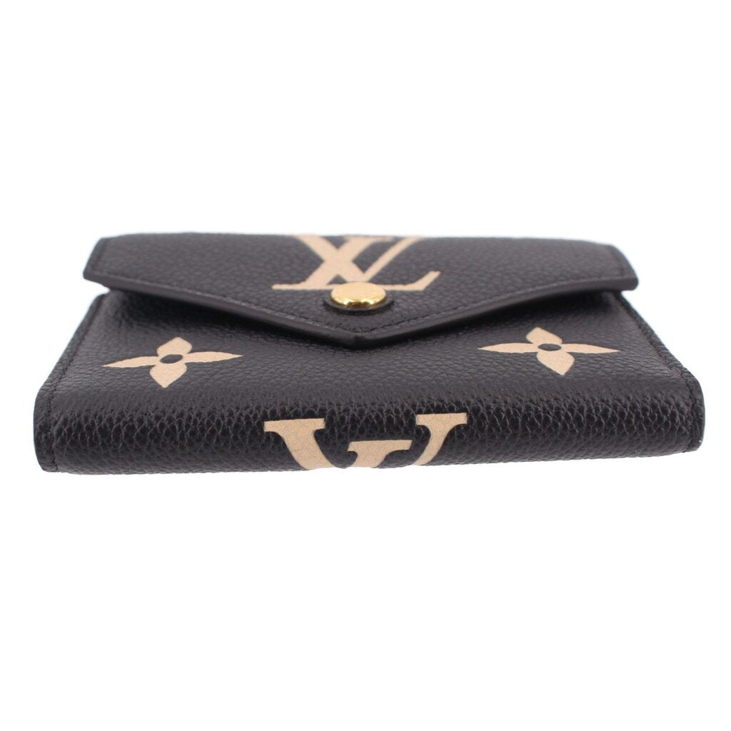 LOUIS VUITTON Victorine wallet back view in black leather with beige monogram and snap