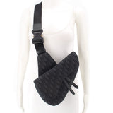Black jacquard saddle crossbody bag worn crossbody with adjustable strap