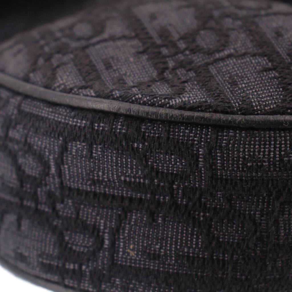 Close-up of black jacquard fabric saddle crossbody bag with textured weave