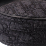 Close-up of black jacquard fabric saddle crossbody bag with textured weave
