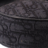 Close-up of black jacquard fabric saddle crossbody bag with textured weave