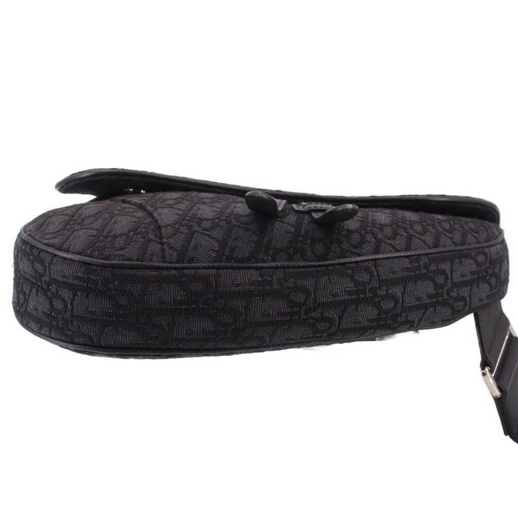 Black jacquard saddle crossbody bag with rolled top edge and side fastening strap