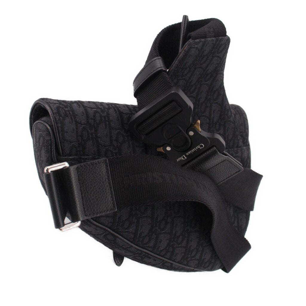 Black jacquard crossbody bag with front buckle hardware and structured flap