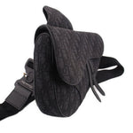 Black jacquard saddle crossbody bag with curved flap, adjustable shoulder strap