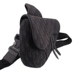 Black jacquard saddle crossbody bag with curved flap, adjustable shoulder strap