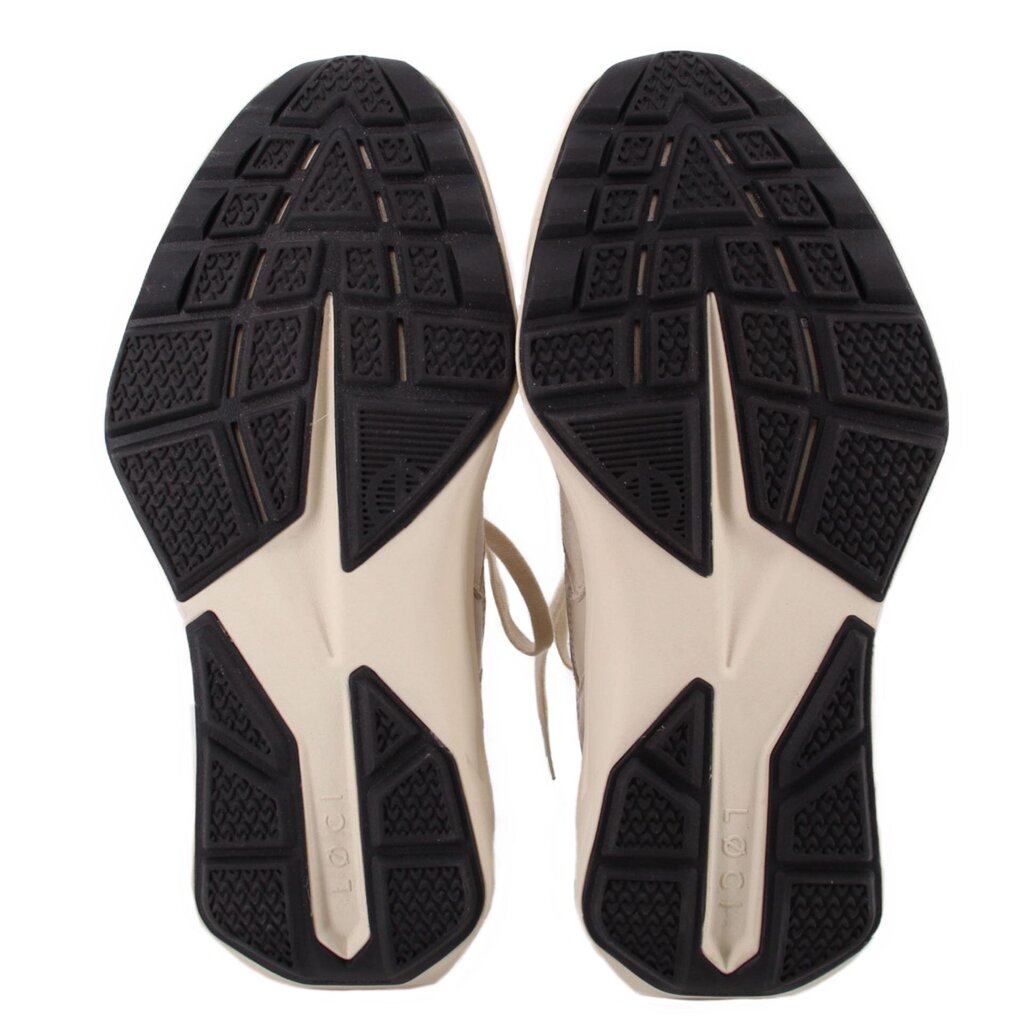Pair of sneakers showing the black patterned rubber outsoles
