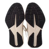 Pair of sneakers showing the black patterned rubber outsoles