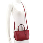 Red mini tote crossbody bag worn on model