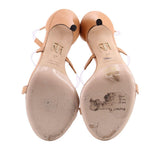 Pair of nude strappy heels shown from below, with visible wear on the soles