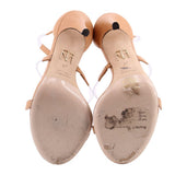 Pair of nude strappy heels shown from below, with visible wear on the soles