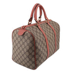 GUCCI Boston handle bag side view, tan GG canvas with rose leather trim and front zip pocket.